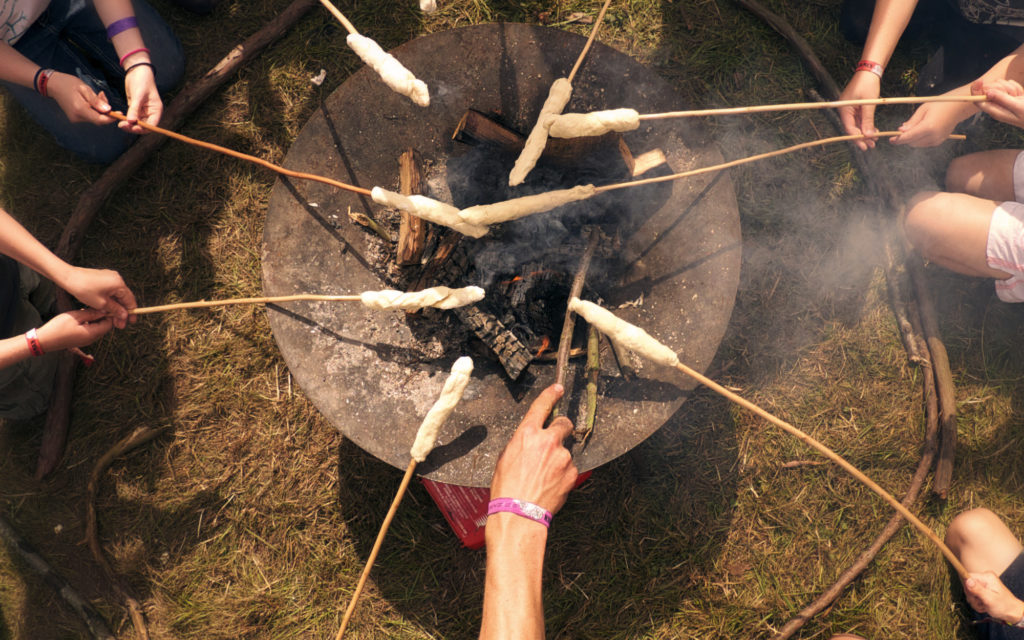 A group at forest school cook some tasty treats on the firewok.